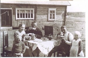 Emäntä Anna (1904-1985) Joukainen on kattanut kahvipöydän kesäpäivänä pihalle. Alajoukaisia oleva Toivo Joukainen (s.1903) istuu kahvipannun takana ja oikealla on Annan veli Anton Sorjonen (1911-1944) Hiivaniemen Kaikon talosta. Joukaisen lapset ovat vasemmalla Aimo (1930-2003) ja oikealla Anja (1928- ). Valoisa maisema ... niinpä tilan nimikin on Päivärinta. 