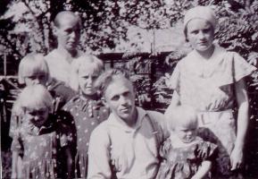 Uutelan toinen veljes Hugo Mikkola pitää sylissään Pirkko- tytärtään ja äiti- Hilja seisoo takana. Saman kankaisissa leningeissään ovat vasemmalla edessä Hilkka ja takana Helli ja Elma. Lasten takana on Eemelin vaimo Tyyne Mikkola. Hugo kaatui 30.11.1941 Seesjärven kaakkoispuolen Suurlahdessa. Kuva on vuodelta 1937.