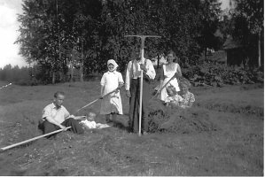 Heinätöissä Kalliorannassa vuonna 1942. Kuvassa oikealta Vieno ja Irma-tyttö, Helmi, Juho-isäntä, Anni-emäntä, pikkutyttö Irja ja talonpoika Aarne. Juho Sipiläisen tekemät uudet haravat peltotöihin. 
