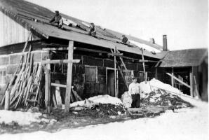 Aholan navettaa korjataan jatkosodan aikana. Miehityksen aikana katto oli revitty pahoin. Sen korjaus valmistui kevättalvella 1942. Etualalla Aksel Ahola ja Ulla.
