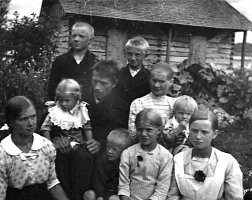 Uustalon isäntäväki Mikko ja Eeva Koskelainen lapsineen talon pihamaalla 1914. Lapset vasemmalta edessä Hilma, Mirja, Vilho, Aino, Reino ja Lydia, takana Hugo ja Toivo.
