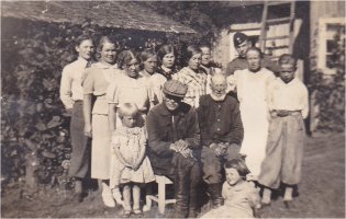 Peltola lohkottiin Vasikkapellosta vuonna 1918 Juhana Juhkominpoika Koskelaisen nimiin. Juhana ja Vaspellon isäntä Juhkom olivat veljeksiä ja menivät naimisiin Ampujan sisarusten (Vanhakylästä) kanssa. Juhkomin vaimo oli Anna Mikontytär Ampuja Vanhakylästä ja Juhanan vaimo oli Helena Mikontytär Ampuja. Heille syntyi kuusi lasta.  Kuvassa istutaan Peltolan pihassa kesällä 1937. Eturivissä lippalakissaan Juhkom-veli naapurista Vaspellosta ja oikealla Juhana-isäntä. Juhanan vaimo oli kuollut jo vuonna 1919. Kuvassa on Vaspellon ja Peltolan väkeä sekä Peltolan vieraita.  (Mariitta Helin)