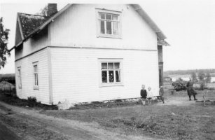 Kuvassa Uus-Mynttisen talo kesäkuussa 1944. Talon seinustalla serkukset Hilkka Antintytär vasemmalla ja Eila Armaksentytär (vaalea yläosa). (Eila Sipola)