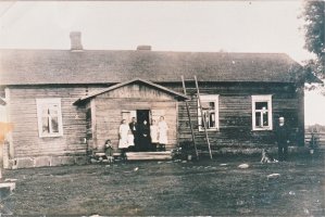 Pyhämäen talo Löytömäellä 1920-luvulla. Kuvassa keskellä tummissa vaatteissa Antti ja Helena (Liena) Käki. Ikkuna vasemmalla puolella kuului opettaja Hilja Tuomelle, joka asui tässä kamarissa. (Pekka Käki)