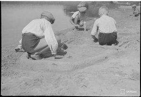6. Käkisalmen Kalliosaaren hiekkarannalta. Pojat rakentavat hiekkaan linnakkeita, joihin uhkaavat tykin piiput syntyvät kaislan korsista, 4.7.1942 (SA-kuva)