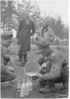 11. Evakot jakavat ohikulkeville joukoille maitonsa, 18.6.1944 (Sot.virk. Kauko Kivi, valokuvaaja, SA-kuva)